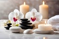 Spa concept, massage stones with towels, candles and white orchids. Royalty Free Stock Photo