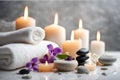 Spa concept, massage stones with towels, candles and wild purple flowers. Royalty Free Stock Photo