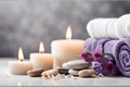 Spa concept, massage stones with towels, candles and wild purple flowers. Royalty Free Stock Photo
