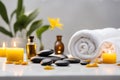 Spa concept, massage stones with towels, essential oil, candles and yellow wild flowers. Royalty Free Stock Photo