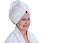 Spa concept portrait. Aged good looking woman with white towel on her headCity background made of many building silhouettes