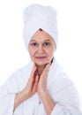 Spa concept portrait. Aged good looking woman with white towel on her headCity background made of many building silhouettes