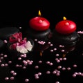 Spa concept of red candles, zen stones with drops, orchid Royalty Free Stock Photo