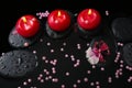 Spa concept of red candles on zen stones with drops, orchid Royalty Free Stock Photo