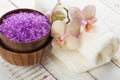 Spa concept. Sea salt in bowl with flowers and towel on white wooden background Royalty Free Stock Photo