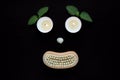 Spa wellness concept, face with eyes candles, a seashell nose and a mouth of a wooden body brush on black background