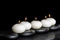 Spa concept of white candles on zen stones with water dew black Royalty Free Stock Photo