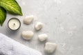 Spa concept with white stone, plant leaves and candle on grey background, top view, copy space. Royalty Free Stock Photo