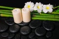 spa concept of zen basalt stones, three white flower frangipani, candles and natural bamboo with dew, closeup Royalty Free Stock Photo