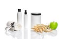 Spa cosmetics, jar of cream, oil with wheat, white cosmetic bottles with apple and wheat towel, candle, soap isolated on