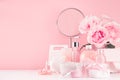 Spa cosmetics products, round mirror, roses in pastel pink and silver color - cream, bath salt, essential oil, soap, bottle, bowl.