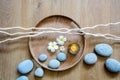 Zen flow of pebbles, candle, flowers and twigs over wood