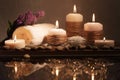 Spa decorative set with sea pebbles, salt, aromatic candles, towel and flower. Golden composition in low key, dark photo