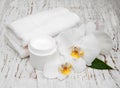 Spa essentials cream white towels and orchids Royalty Free Stock Photo