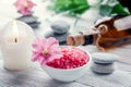 Spa essentials including candle, salt, stones, oil and green leaves