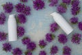 Spa and facial beauty herbal cosmetics with flower on blue wooden background. Spring skin care trends. Top view branding concept
