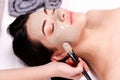 Spa facial mask application. Beautiful relaxed woman having clay face mask in the spa