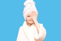 Spa girl. Beautiful blue-eyed child girl in white robe and towel on her head after bath touch face. Perfect Skin. Skincare Royalty Free Stock Photo