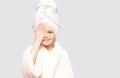 Spa girl. Beautiful blue-eyed child girl in white robe and towel on her head after bath touch face. Perfect Skin Royalty Free Stock Photo