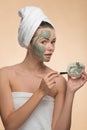 Spa girl with a towel on her head applying facial Royalty Free Stock Photo