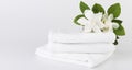 Spa and health care concepts setup with stack of white towels and tropical Gardenia flowers on white background