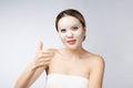 Spa, healthcare. Asian girl with a cosmetic mask with showing thumb up. Royalty Free Stock Photo