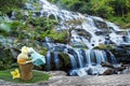 Spa herbal compressing ball,white frangipani flower,turmeric powder in white spoon massage oil in bamboo basket at waterfall Royalty Free Stock Photo