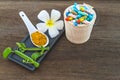 Spa herbal white frangipani flowers, turmeric powder in white spoon ,pill,Cissus Quadrangularis Linn on wooden background Royalty Free Stock Photo