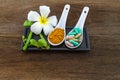 Spa herbal white frangipani flowers, turmeric powder in white spoon ,pill,Cissus Quadrangularis Linn on wooden background Royalty Free Stock Photo