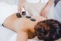 Spa hot stone massage. woman lying on the bed relax with spa hot stone on her back Royalty Free Stock Photo