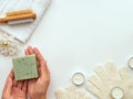 Hands holding Handmade green Soap with bath accessories on white light green background Royalty Free Stock Photo