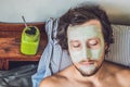 Spa man applying Facial green clay Mask. Beauty Treatments. Fresh green smoothie with banana and spinach with heart of sesame seed