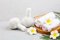 Spa massage Aromatherapy body care background. Spa herbal bags, towel and tropical flowers on gray concrete table. copy space. Royalty Free Stock Photo