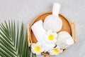 Spa massage Aromatherapy body care background. Spa herbal balls, cosmetics, towel and tropical leaves on gray concrete table. Top Royalty Free Stock Photo