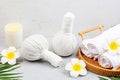 Spa massage Aromatherapy body care background. Spa herbal bags, towel and tropical flowers on gray concrete table. copy Royalty Free Stock Photo