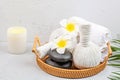 Spa massage Aromatherapy body care background. Spa herbal bags, towel and tropical flowers on gray concrete table. copy space. Royalty Free Stock Photo