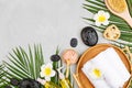 Spa massage Aromatherapy body care background. Spa herbal balls, cosmetics, towel and tropical leaves on gray concrete Royalty Free Stock Photo