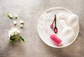 Massage herbal balls, bath salt and white flowers top view, flat lay on gray concrete background