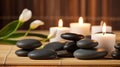 Spa Massage basalt stones with candles, lotus flowers, orchid flower and towels on bamboo mat. Generative AI Royalty Free Stock Photo