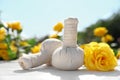 Spa massage herbal bags with yellow rose on white table in garden. Harmony and zen