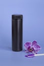 Spa mockup: purple cosmetic sea salt spa, black plastic bottle with salt, purple orchid on blue background