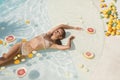 SPA Model In Pool With Citrus. Beautiful Girl In Bikini Floating With Fresh Tropical Fruit At Resort.