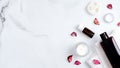 SPA natural organic bath oil, lotion, cream with bath towel and rose flower petals on marble background. Body care, clean skincare Royalty Free Stock Photo