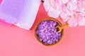 Spa on a pink pastel background. Towels, stones, aromamaslo, purple salt bath and pink flowers. Royalty Free Stock Photo