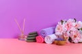Spa on a pink pastel background. Towels, stones, aromamaslo, purple salt bath and pink flowers. Royalty Free Stock Photo