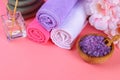 Spa on a pink pastel background. Towels, stones, aromamaslo, purple salt bath and pink flowers. Royalty Free Stock Photo