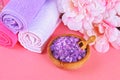 Spa on a pink pastel background. Towels, stones, aromamaslo, purple salt bath and pink flowers. Royalty Free Stock Photo