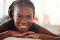 Spa, portrait and black woman with smile, massage and salon luxury treatment, bare and lying on table. Face, African