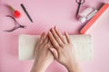 Spa procedure for nail care in a beauty salon. Female hands and tools for manicure on pink background. Bodycare concept Royalty Free Stock Photo