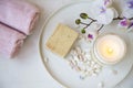 Spa products still life, top view of scented candle, natural soap and cotton towels Royalty Free Stock Photo